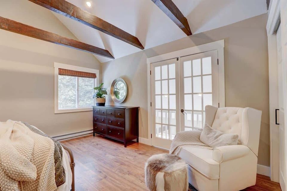 Master Bedroom: Elegant space with rustic beams, natural light, and a charming reading nook!


