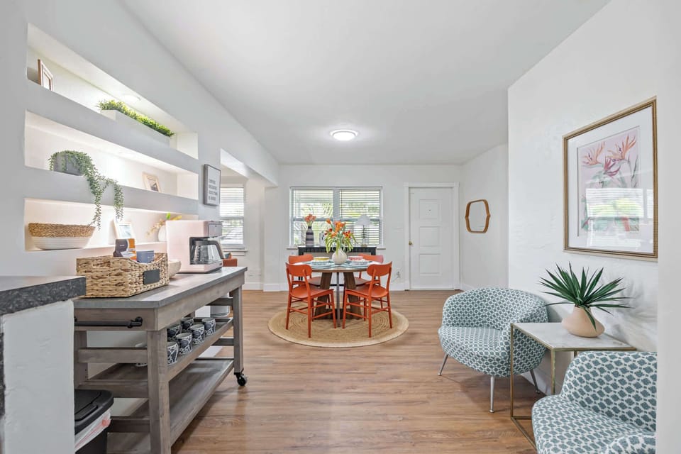 Bright dining area with orange chairs and natural light for a welcoming atmosphere.