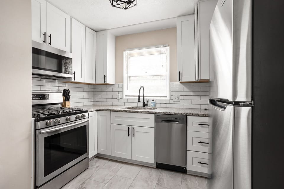 Modern kitchen with stainless steel appliances, subway tile backsplash and all of the necessities for your stay!