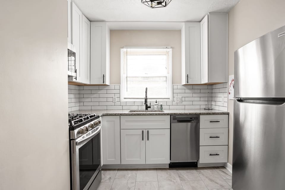 Modern kitchen with stainless steel appliances, subway tile backsplash and all of the necessities for your stay!