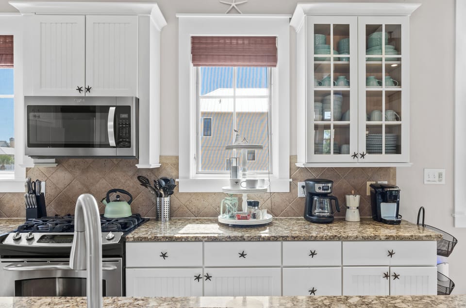 White kitchen with stainless-steel appliances and coffee station.