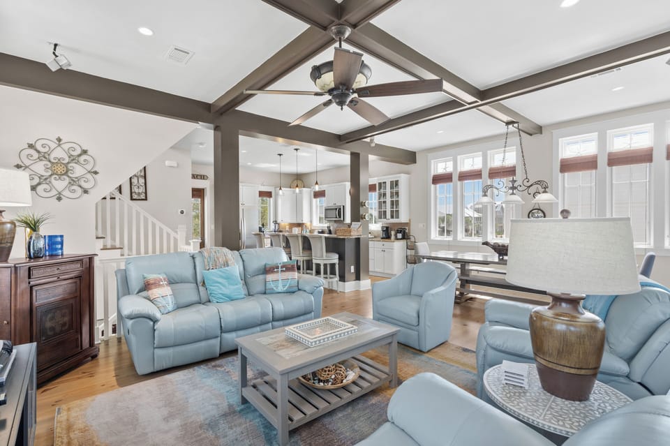 Open-concept living and dining space with exposed beams.
