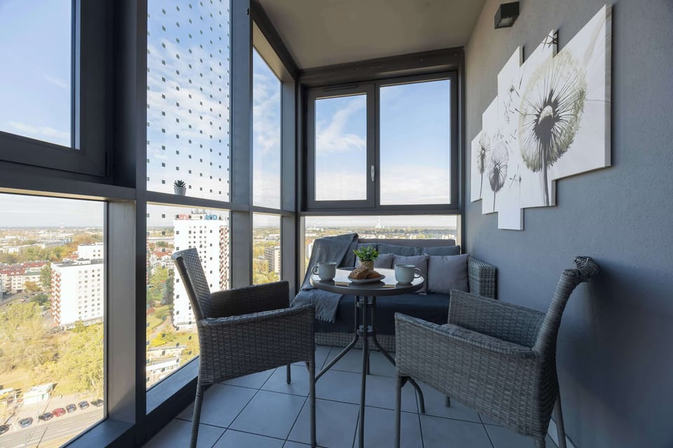 Spacious balcony with outdoor furniture and a city view.
