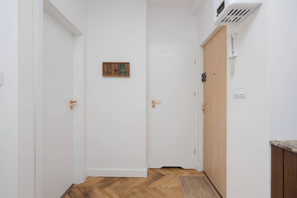 A bright hallway with a wooden floor and minimalist décor welcomes you into a space full of calm and order.