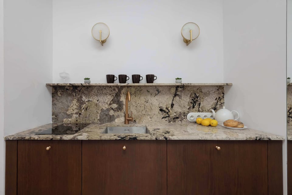 A carefully styled countertop with fruit and ceramics creates a pleasant, homely atmosphere in the heart of the apartment.
