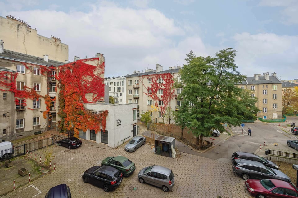 A charming courtyard with colorful façades and greenery offers an intimate space for a moment of relaxation outdoors.