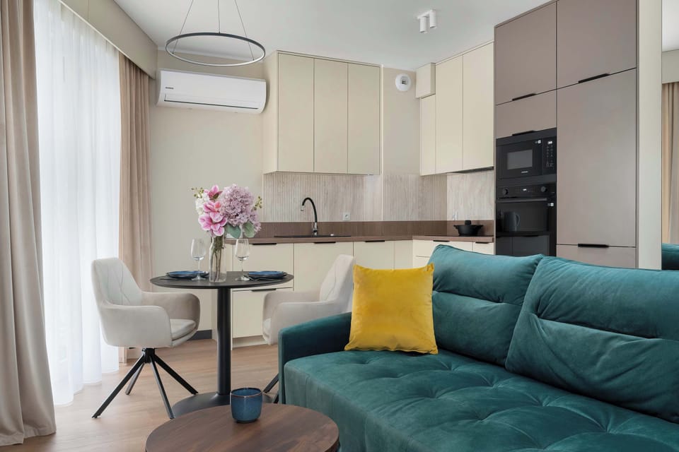 Dining area connected to living room with round table and comfortable chairs for shared meals.
