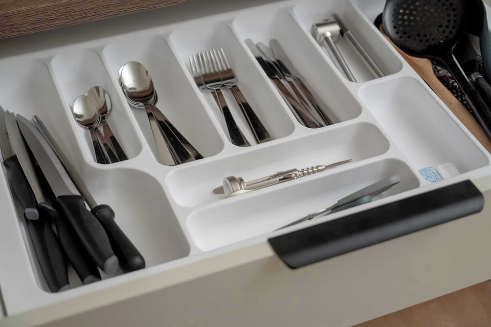 Organized kitchen drawer with complete set of cutlery and utensils.