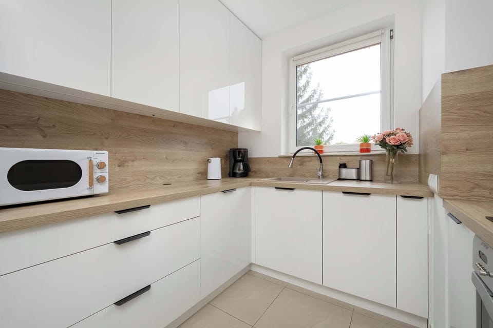 A kitchen with white cabinetry and a modern stove, clean and minimalistic design.