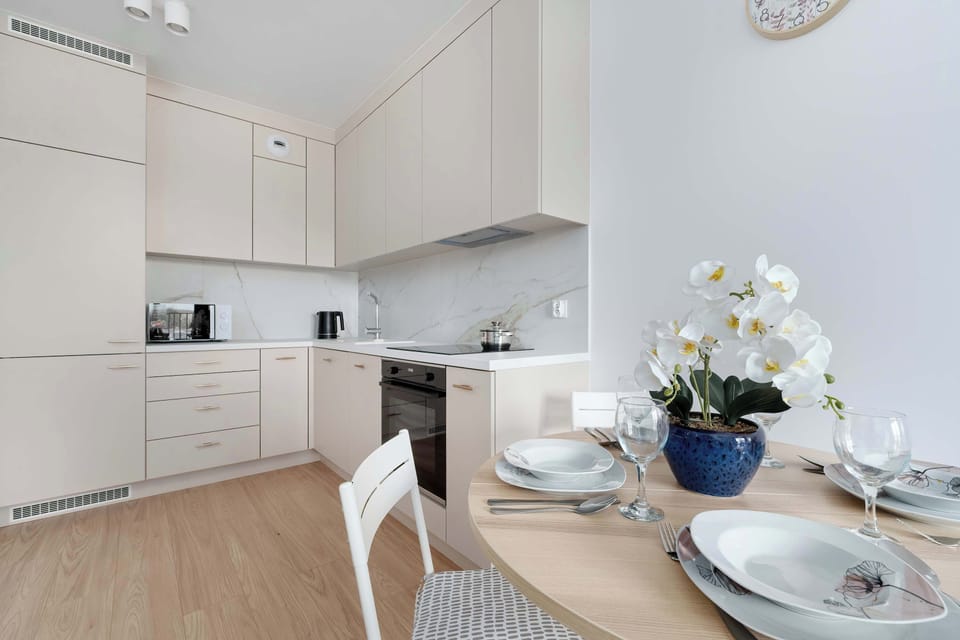 A bright kitchen with smooth cabinets and a marble countertop creates a modern space perfect for preparing meals.
