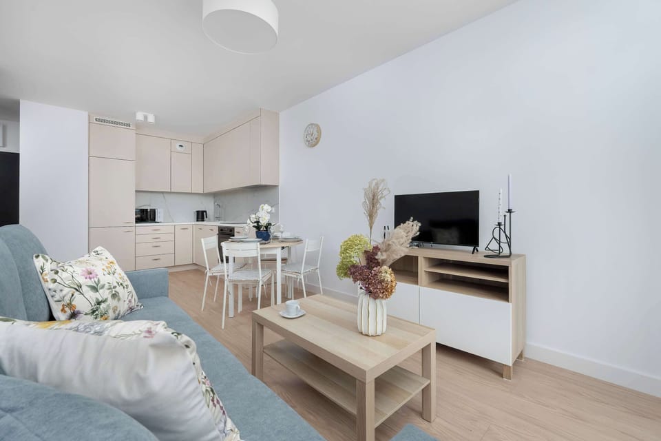 A comfortable sofa opposite the TV and bright accessories bring a sense of homely warmth to the interior.
