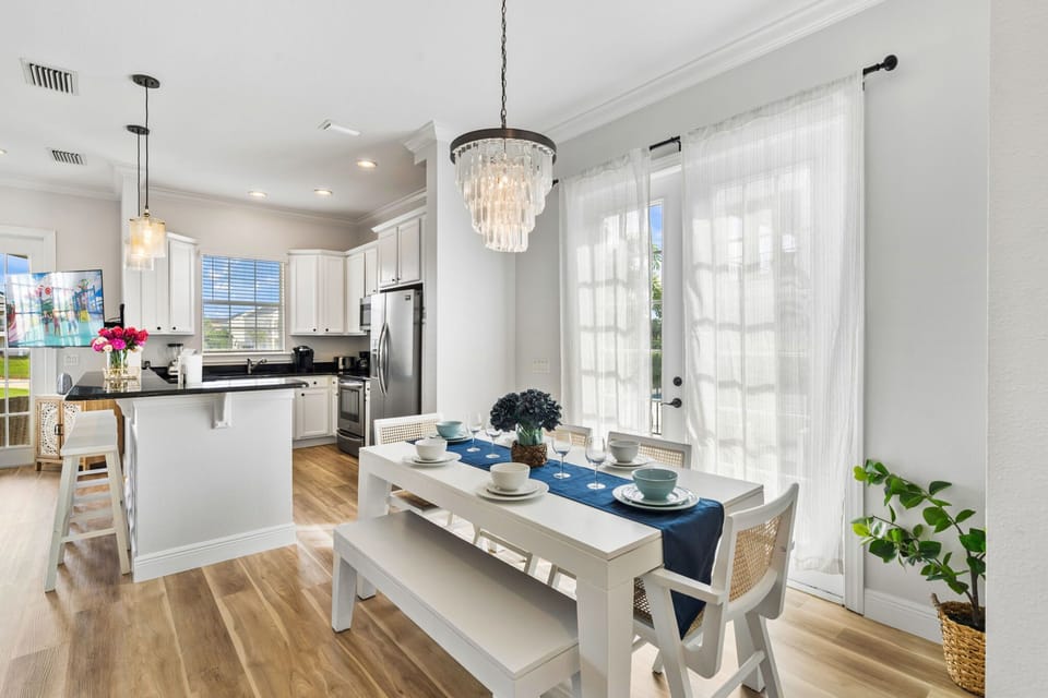 Elegant Dining Space with Crystal Chandelier and Open Kitchen