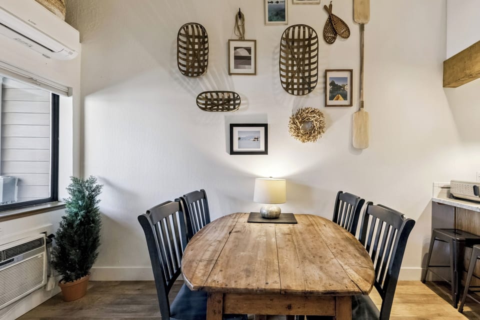 Gather around your rustic wood dining table beneath charming wall art for memorable meals together.