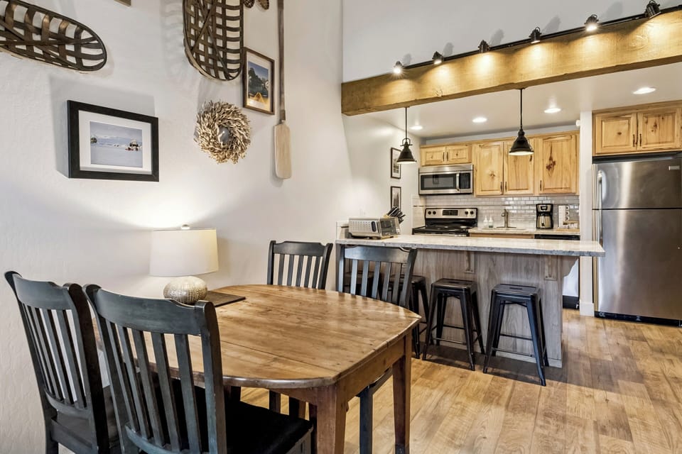 Your open-concept kitchen and dining space blends rustic charm with modern comfort, featuring exposed beams and a welcoming table for memorable meals.