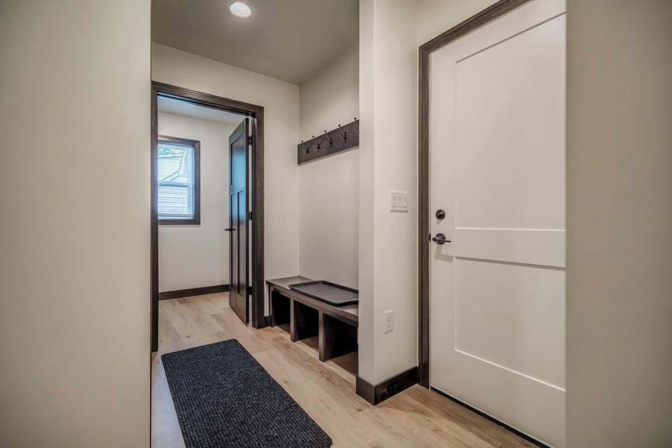 Shot of the garage door entry area featuring built-in lockers for coats and shoes, leading into a full laundry room with washer, dryer, and supplies. A functional space designed to keep things tidy and convenient during your stay.