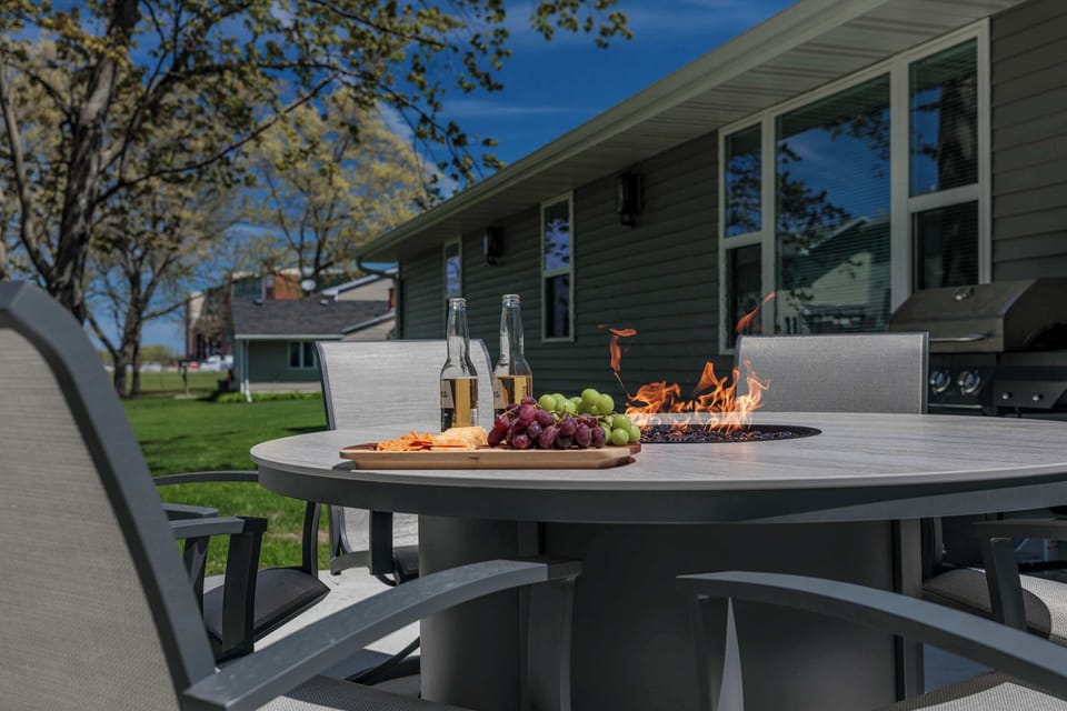 Kick back by the fire table with cold drinks and snacks while enjoying iconic views of Lambeau Field glowing in the background. The perfect backyard setup for unforgettable Packers weekends and late-night hangs.