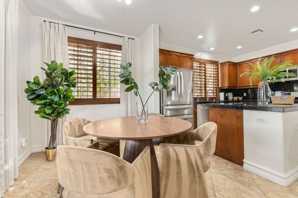 Open dining area w/ statement table, greenery & seamless flow into the kitchen for shared meals and easy hosting.