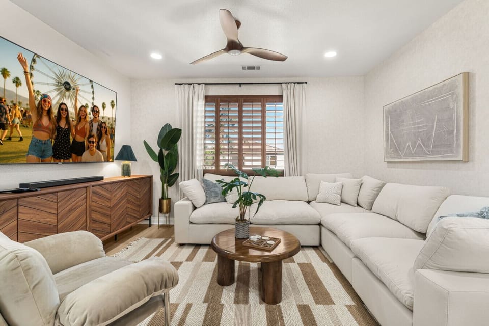 Bright living room w/ plush seating, warm wood accents & natural light—an inviting spot to relax after a full day out.