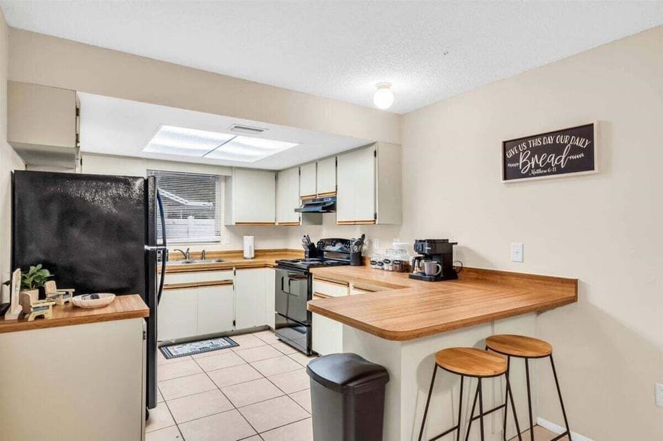 Full kitchen with a refrigerator, oven, and coffee station