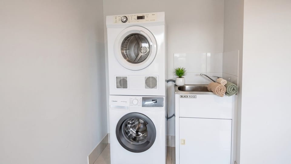 `Enjoy the convenience of an in-unit stacked washer and dryer, complete with a utility sink and fresh towels`