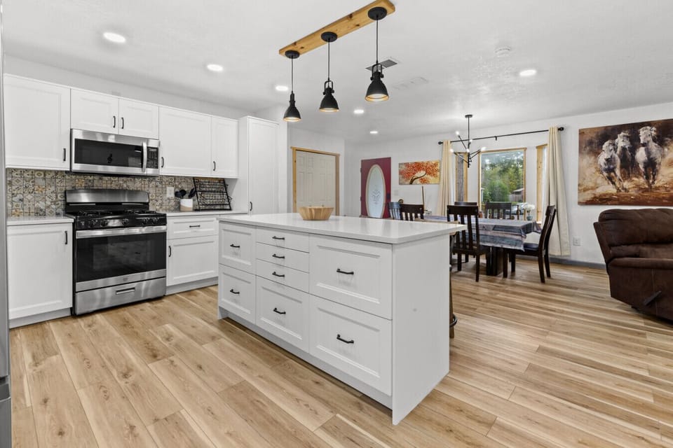 Bright open kitchen with island and modern appliances, steps from the dining table and living space.