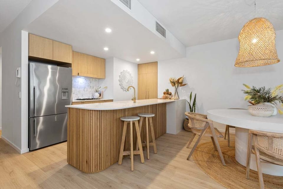 Spacious kitchen with island seating and stylish lighting.