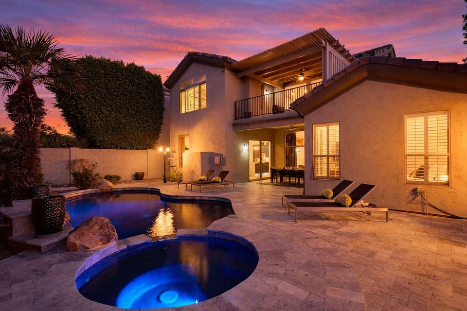 Backyard oasis featuring a covered patio w/ dining, sparkling pool with spa, plus a built-in grill and fireplace perfect for outdoor gatherings.