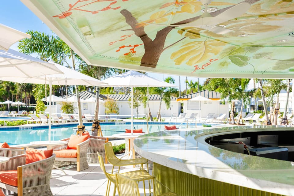 Gather with friends at the vibrant poolside bar featuring stylish seating, shaded comfort, and a welcoming social atmosphere