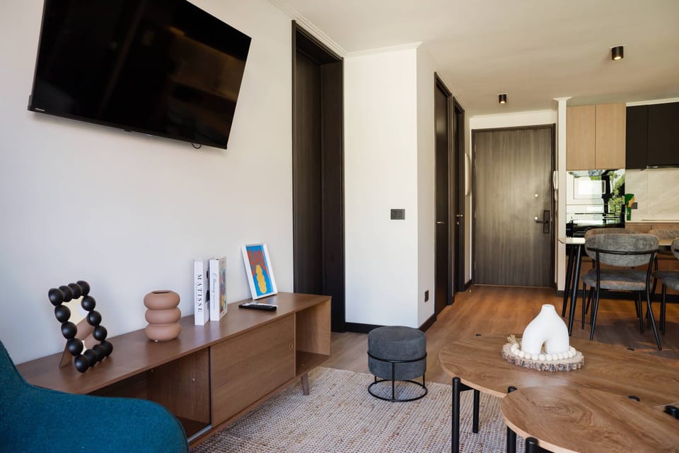 Cozy living area with modern decor and a wall-mounted TV, perfect for relaxation.