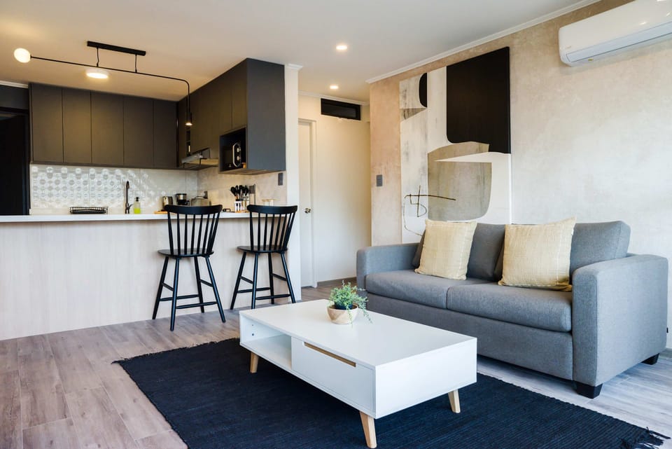 Enjoy the open-concept design that seamlessly connects the living room and the kitchen. The plush, comfortable sofa and the stylish breakfast bar are perfect for both relaxing and socializing while you prepare a meal.