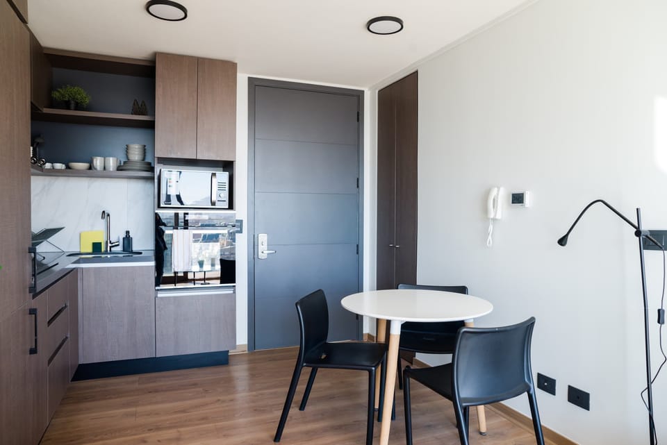 Modern and efficient kitchen with sleek cabinets and a cozy dining area, perfect for intimate meals.