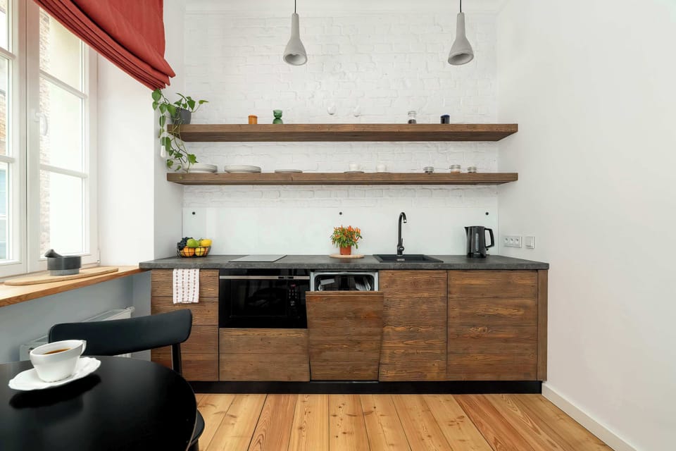 Functional and modern kitchen with hanging lights and open shelving.