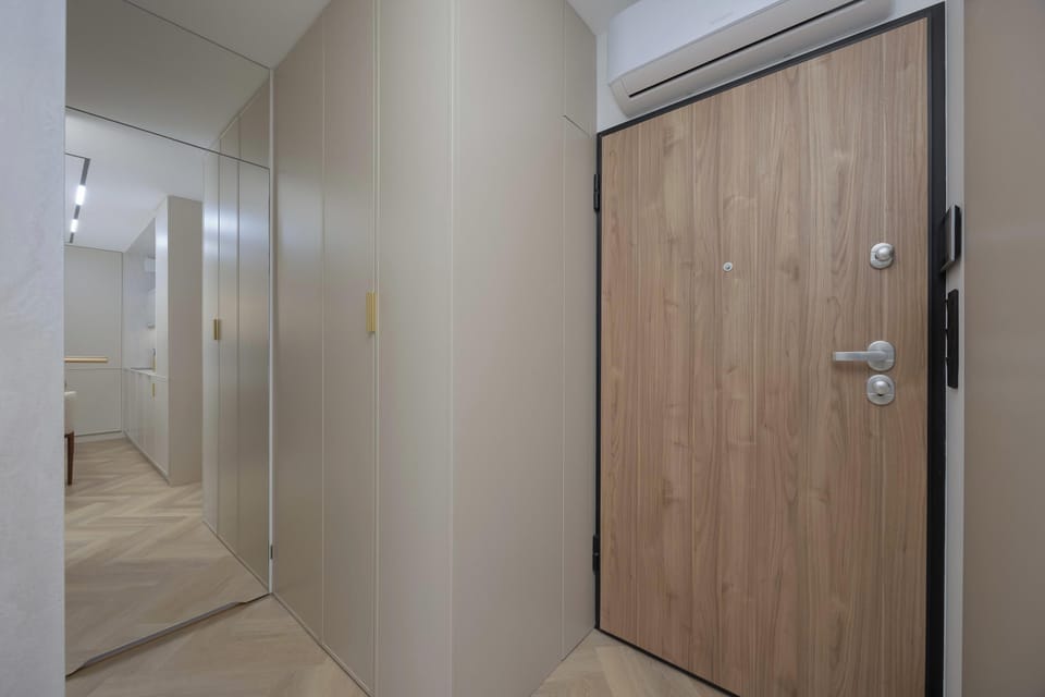 The bright hallway with wooden accents and concealed lighting creates a pleasant first impression upon entering the apartment.