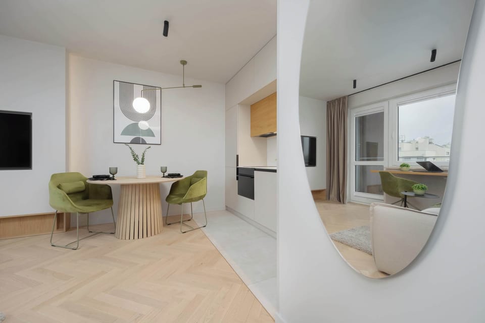 The large mirror visually expands the space and adds elegance to the combined living and dining area.