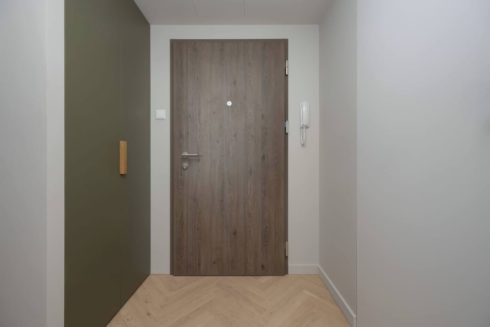 The spacious hallway with wooden accents welcomes guests with a warm, modern design.