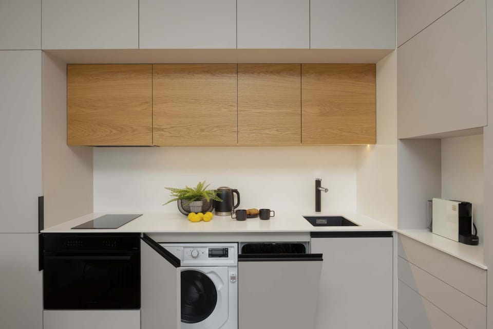 The modern kitchen with light cabinets and wooden accents is perfectly organized and functional.