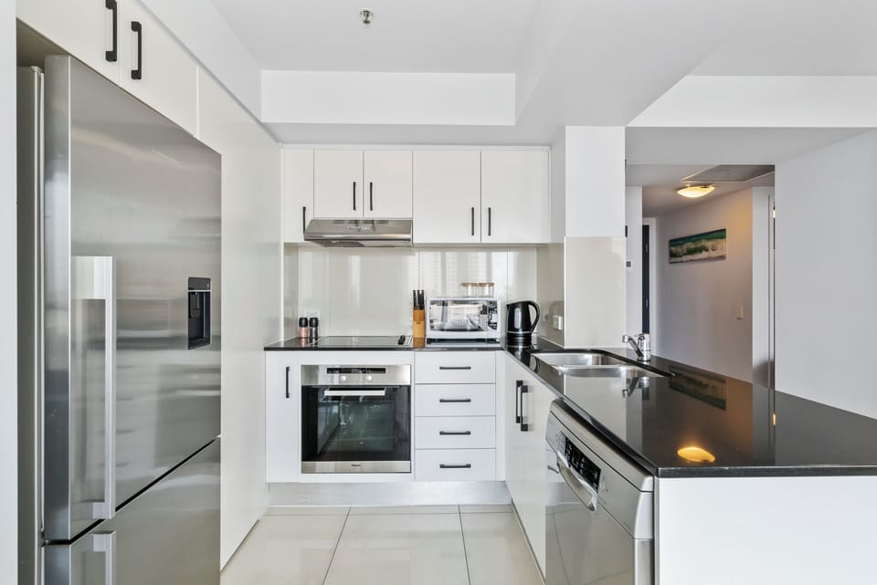 The kitchen’s stainless-steel appliances make cooking effortless, with a pour-over coffee setup, oven, microwave, dishwasher, and full-size fridge ready for relaxed home dining.