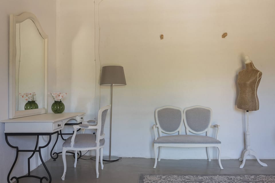 Elegant seating corner at Finca Binissati in Inca featuring classic white furniture and Mediterranean rustic décor.