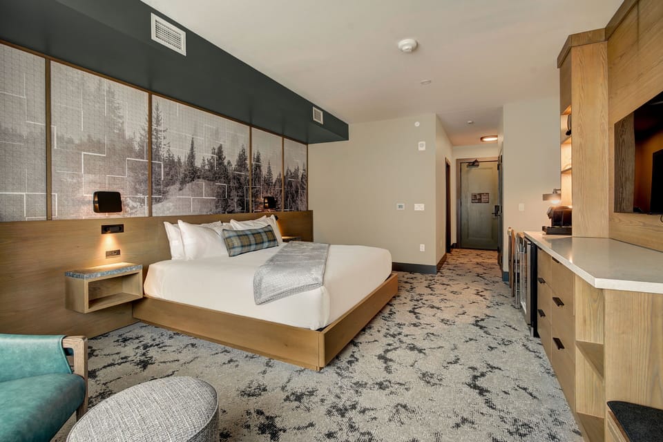 King bed, wall-mounted TV, and warm lamp glow after a full day on the slopes