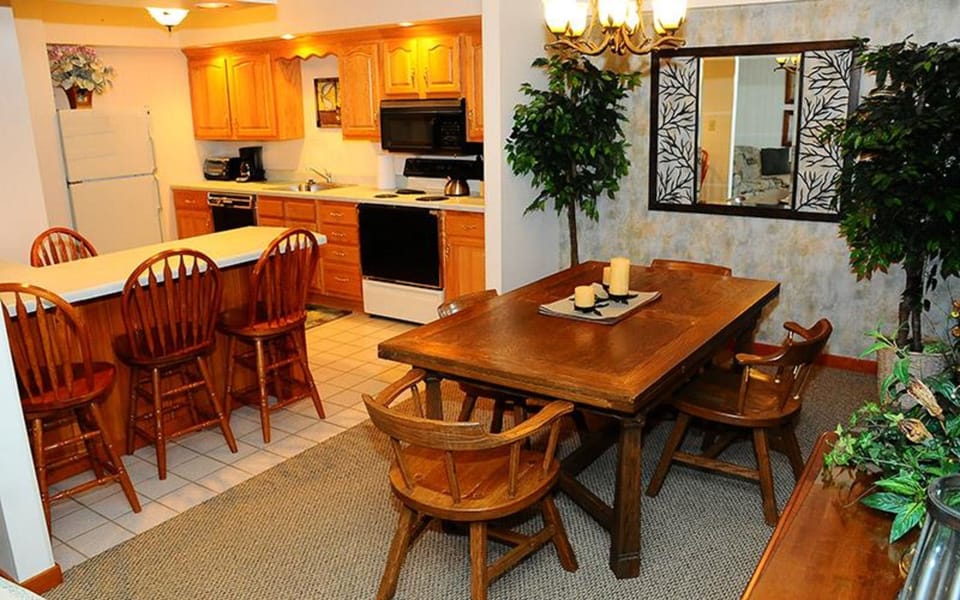 An open-plan kitchen and dining space highlighted by rich wood tones and a rustic dining table, creating an inviting atmosphere for meals.