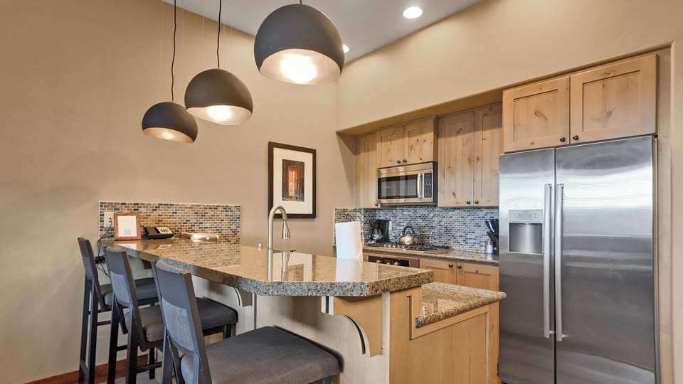 Kitchen with granite counters and modern stainless appliances.