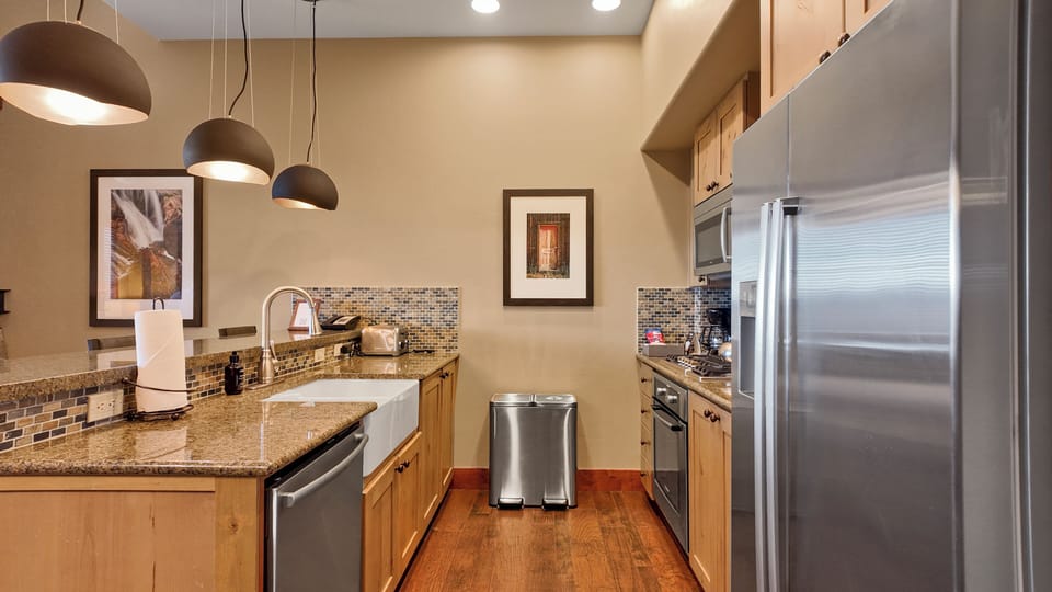 Fully equipped kitchen with breakfast bar and pendant lighting.