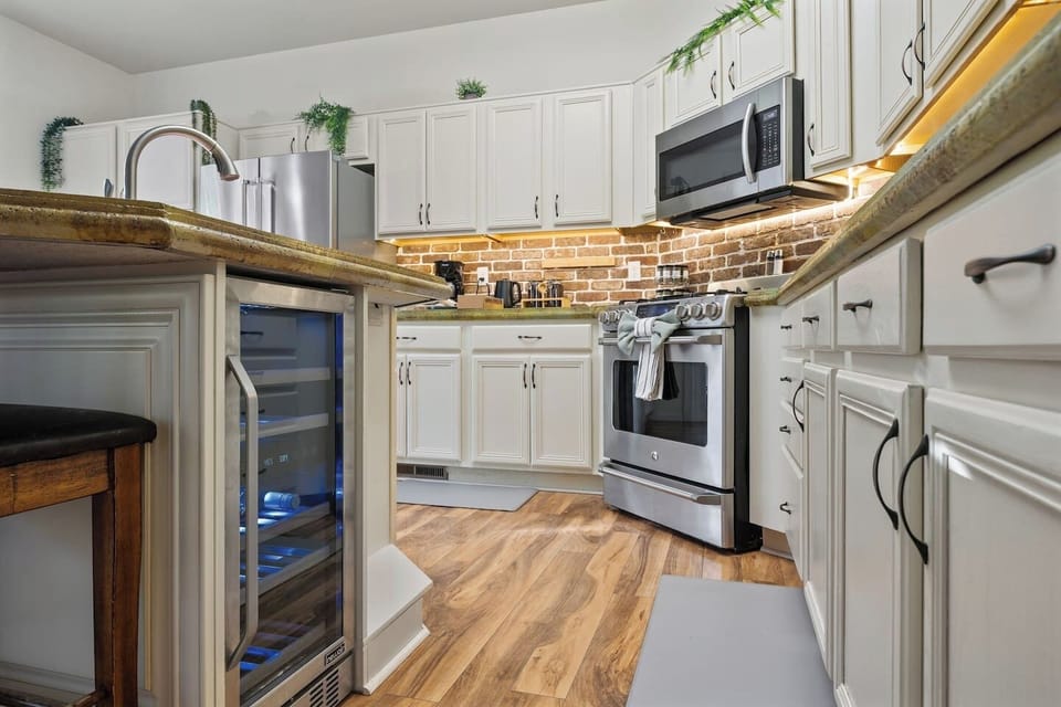Chef’s kitchen with stainless appliances and modern lighting.