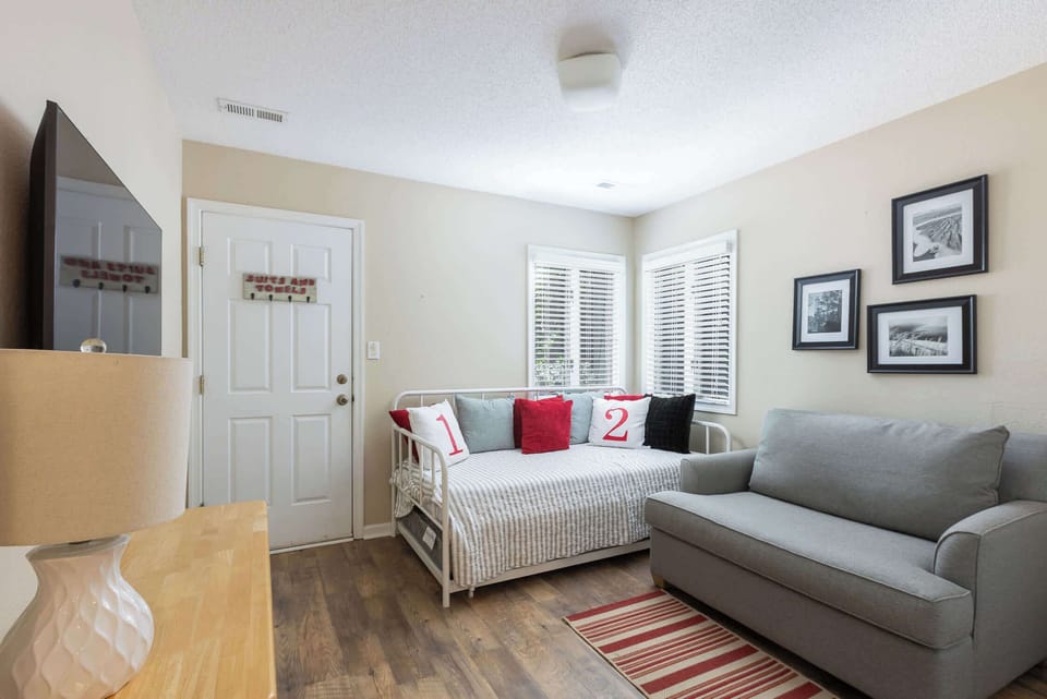 Ground Level: Bedroom Featuring a Daybed with Trundle, Sleep Chair, TV, and Patio Access