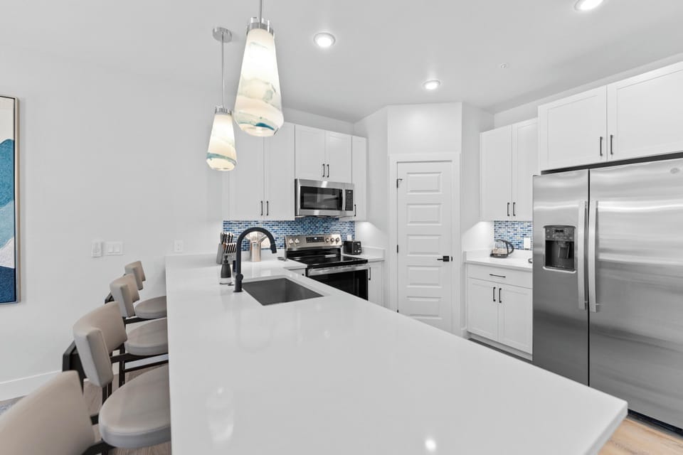 Full kitchen with stainless steel appliances and breakfast bar seating