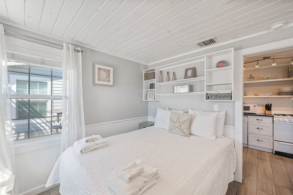 Your cozy retreat features a comfortable bed with built-in storage shelves and seamless kitchen access for ultimate convenience.