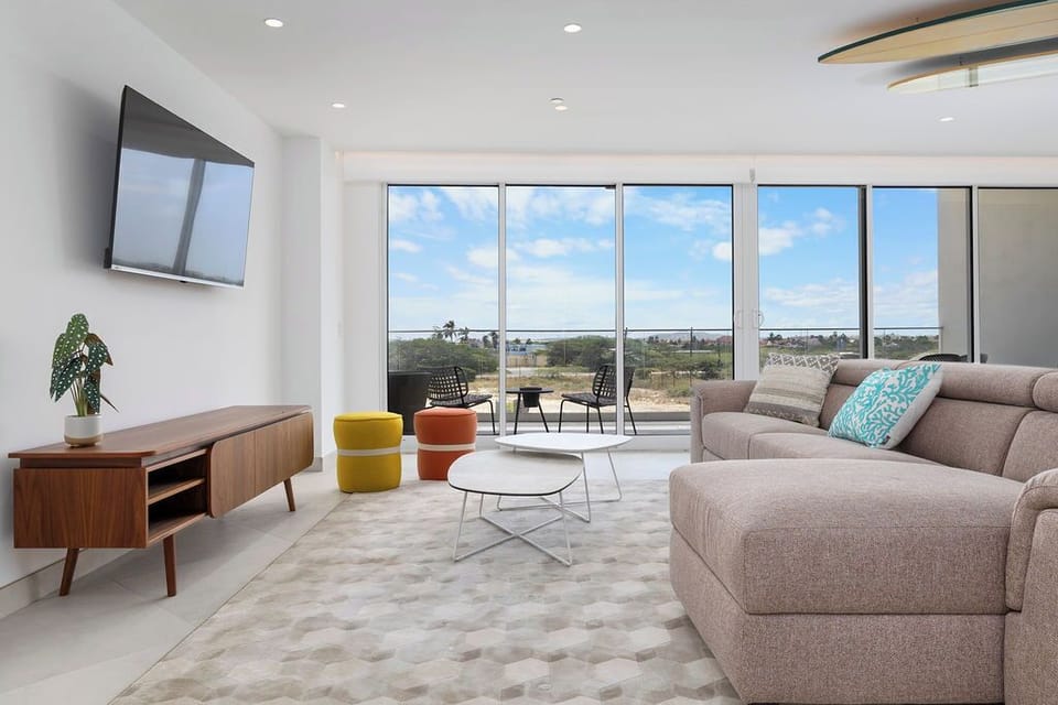 Sink into your plush sectional and enjoy panoramic vistas through floor-to-ceiling windows. Natural light fills this airy living space, creating your perfect retreat to unwind and recharge.