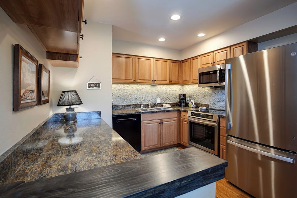 Your fully equipped kitchen features granite counters, stainless appliances, and warm wood cabinets—perfect for creating memorable meals during your stay.