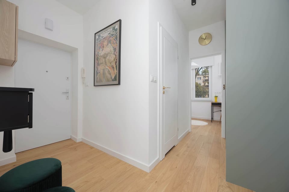 Wide hallway connecting rooms with modern artwork and bright wooden floors.