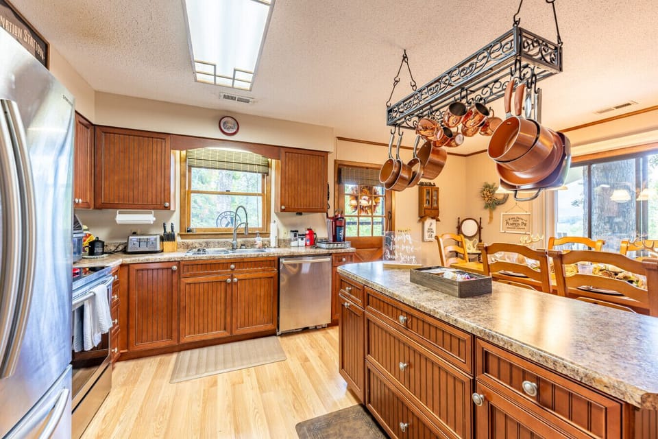 Kitchen | Fully equipped with stainless steel appliances, wood cabinetry, and ample counter space.